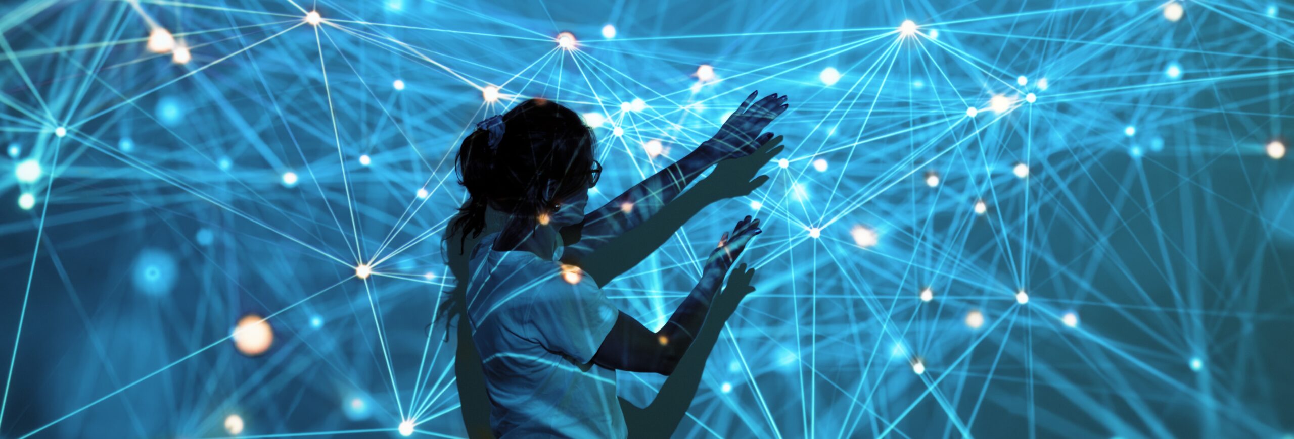 Pääkuva turkoosilla taustalla, jossa loistava verkosto kultaisilla pisteillä. Nainen on keskellä digitaalista verkostoa, joka heijastuu häneen ja jota kohti hän kurkottaa.